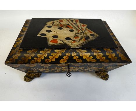 A 19thC playing card box with a hinged lid, decorated with oak leaves and a part deck of cards, on gilt metal claw feet&nbsp;