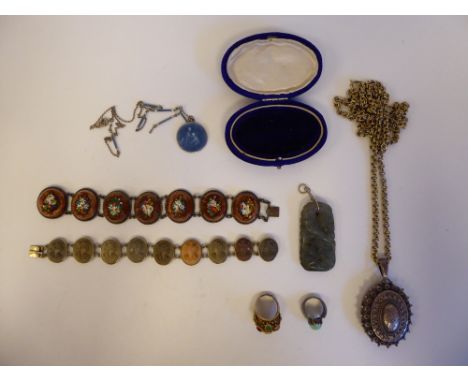 Items of personal ornament: to include an oval silver pendant, decorated in ethnic taste, on a white metal chain; and a silve