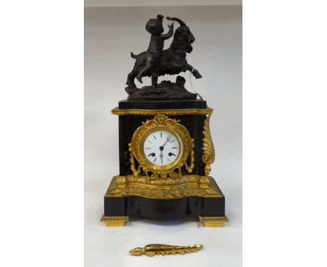 A late 19thC black slate cased and gilt metal mounted mantel clock, surmounted by a classical 'goat man' with a cherubic figu