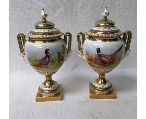 A pair of modern Royal Worcester porcelain two-handled covered Vases of ovoid form on moulded pedestal and square plinth, han