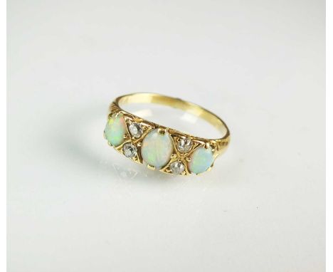 A seven stone opal and diamond ring, designed as three graduated oval opals interspersed with four old cut diamonds, the yell