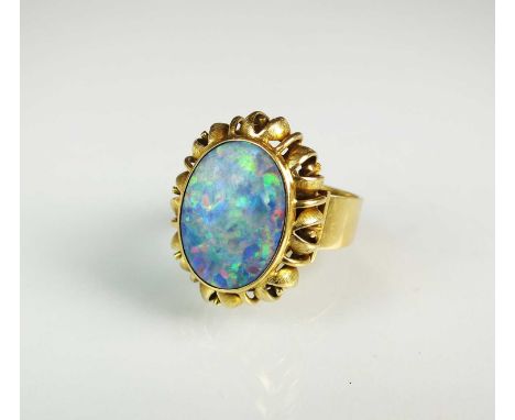 An opal doublet dress ring, designed as an oval opal doublet set within decorative pierced mount, the shank stamped '585', ri