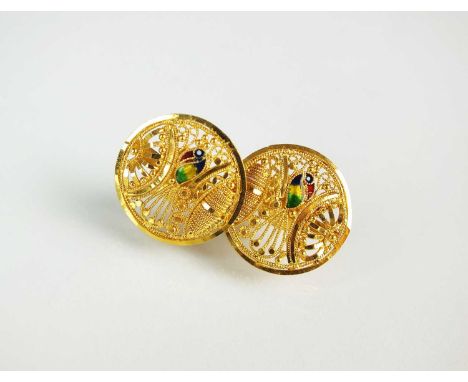 A pair of yellow metal and enamel earrings, each designed as a circular pierced scroll work plaque with central enamelled bir
