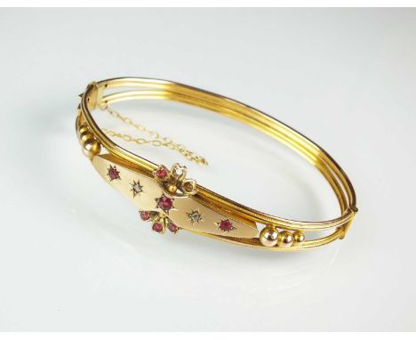 A garnet topped doublet and rose cut diamond hinged bangle, the reeded band with box link clasp stamped '9c', with attached s