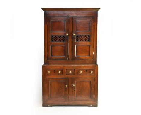 A small, well-proportioned, early 19th century oak housekeeper's cupboard, with ebonised inlaid kite-shaped escutcheons, the 