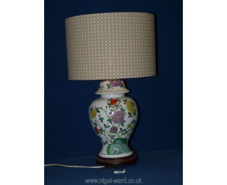 An oriental style china ginger jar lamp base with floral design and shade standing on wooden plinth 20" tall (base 12" tall).