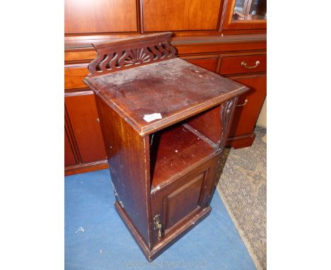 An Edwardian Mahogany bedside Cabinet having a raised and fielded panelled door with an open shelf over and with a fretworked