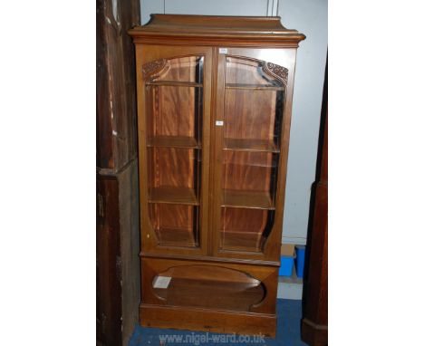 A continental design Satinwood Bookcase having shaped bevelled glazed doors, adjustable shelves and caddy type top, the base 