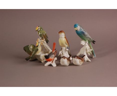 A group of porcelain and pottery birds, including a budgerigar, a finch with damaged becks, pair of wrens, a pair of small gr
