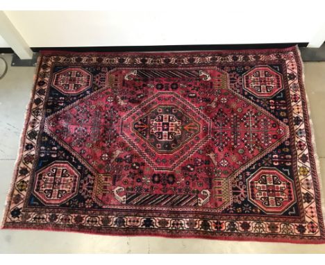 A vintage middle eastern woollen carpet,  Sizes 282cm by 190 cm, with red ground on geometric designs