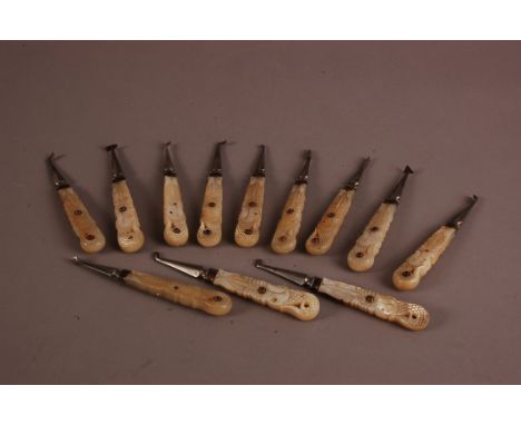 A set of twelve fine 19th century Indian dentist's tools, with carved mother of pearl handles set with semi-precious stones, 