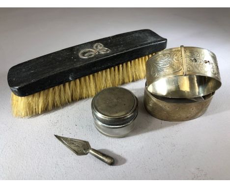 Collection of silver items to include a pair of bangles, silver lidded pot, trowel book mark and a silver monogramed brush