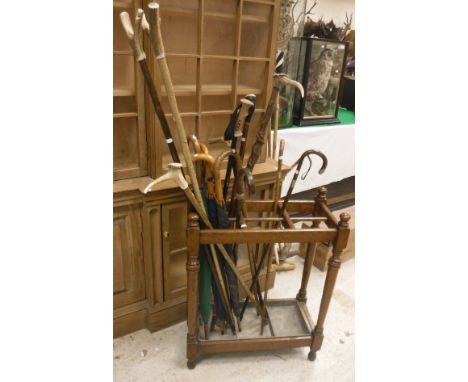 An oak six section stickstand together with four various walking sticks with silver ferrules, two thumbsticks, four further v