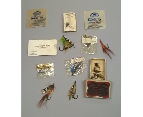 A Megan Boyd business card contained in an envelope with four hand tied Atlantic salmon flies, a packeted Hardy fly and one o