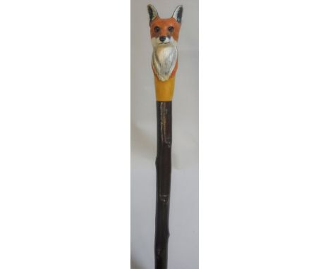 A walking stick with carved and painted fox head finial by Mike Wood