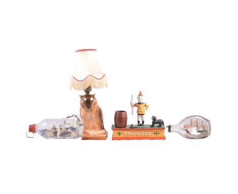 Novelty pottery owl lamp, overall 20cm; two ships in glass bottles, 19cm and 17cm long; and a reproduction coin bank 'Trick D