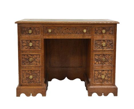 Victorian oak kneehole desk, leather inset top, carved edge and drawers, kneehole surrounded by nine drawers, bracket feet, w