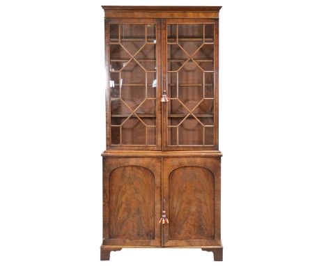 William IV mahogany bookcase cabinet, matched, the top with key and cavetto cornice, astragal glazed doors enclosing three fi
