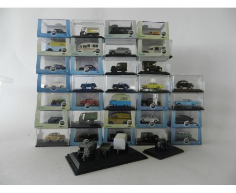 Thirty four boxed Oxford Diecast models in 1:76 scale to include commercial vans, saloon cars, a tractor and implements