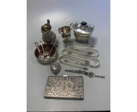 A collection of silverware including sugar nips, tea caddy, cram jugs, bottle coaster etc together with some continental silv