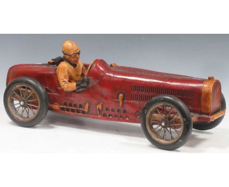 A wood and resin single seater toy car, with fixed driver