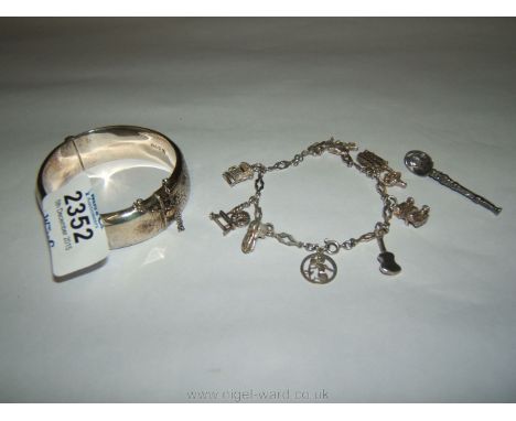 A Silver Bangle and a broken Silver Charm Bracelet with ten charms, together with a Silver anointing spoon Brooch