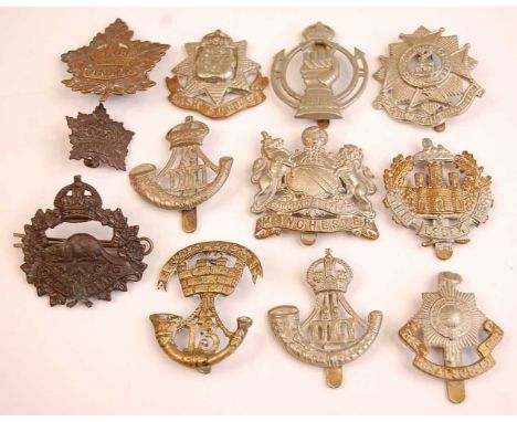 A collection of cap badges and insignia to include Royal Armoured Corps, Durham Light Infantry, Royal Flying Corps, 10th Cana