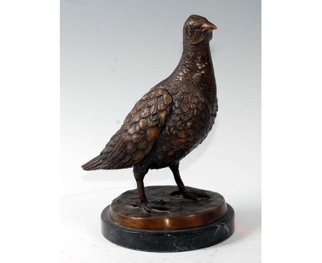 A contemporary bronzed model of a partridge in standing pose, on a naturalistic base and marble plinth, h.25cm.