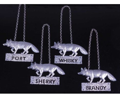 A set of four decanter labels, each in textured silver and surmounted by a fox, annotated for Brandy, Port, Sherry and Whisky