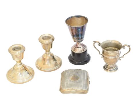 A selection of silver, to include two cups, a cigar case, and pair of candlesticks, gross weight of solid silver items 6.43oz