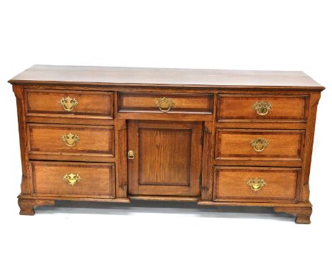 George III oak dresser base, rectangular two plank top with moulded edge, carcass containing seven short drawers, each with m