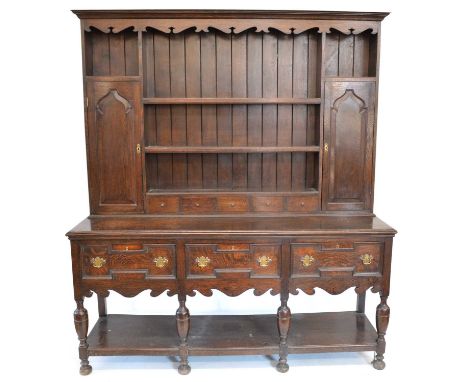 Early 20th-century Jacobean style oak dresser, the upper section with fretwork frieze, three fixed shelves with five-spice dr