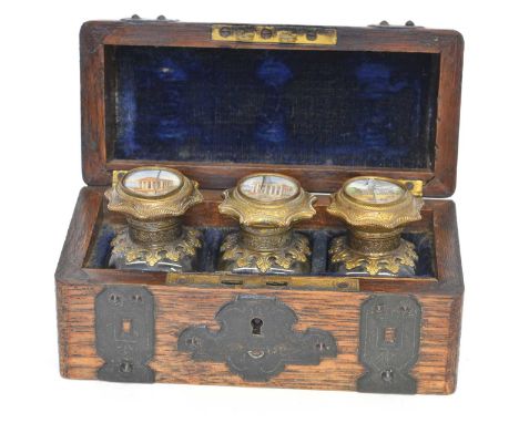 Continental oak tabletop casket, fretwork brass strap handles opening to reveal three clear glass bottles with brass mounts, 