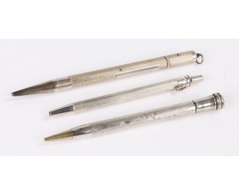 Three silver pencils with engine turned bodies, 10.5cm, 9.5cm and 9cm long (3)