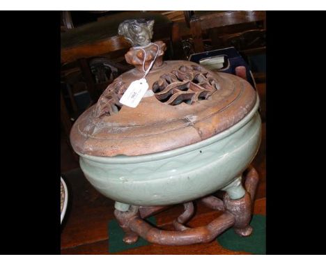 An antique oriental Celadon bowl - 32cm diameter - with raised foliate decoration on unusual carved wooden stand - the wooden