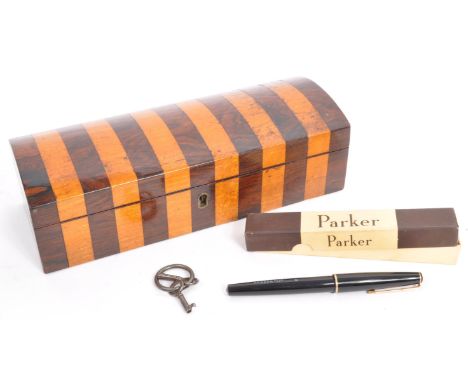 An early 20th century wooden marquetry pen box of domed form with inset inkwell slot. Accompanied by key and a boxed parker "