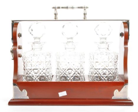 A contemporary three decanter bottled tantalus white metal bound. Having a lock carry handle (no key) with three glass crysta