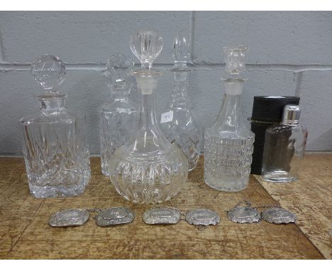 Five glass decanters including crystal, six wine labels and a hip flask in travel case 