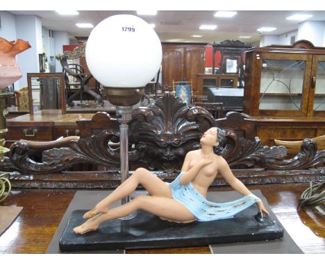 A Circa 1930's Art Deco Lamp, featuring  a lady in repose next to white glass globe, on chrome lamp base, 46cm wide.