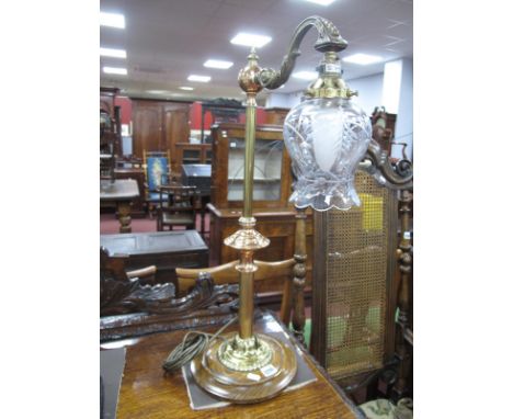 A XIX Century Style Brass Table lamp, with a scroll shaped support holding a clear glass shade, on a circular base, 67cm high