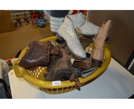 A basket of various vintage shoes and ice skates 