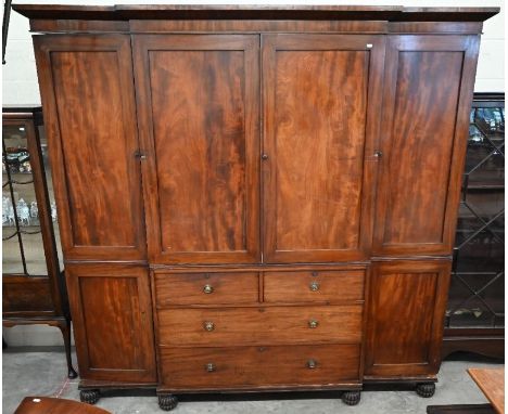 A large 19th century mahogany breakfront wardrobe, the central section with cupboard doors over two short and two long drawer