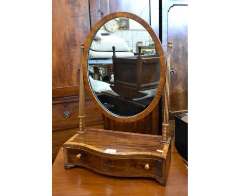 A 19th century mahogany crossbanded toilet mirror with oval plate and serpentine fronted platform base fitted with single dra