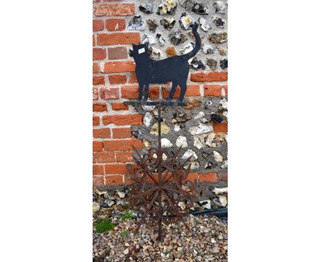 A wrought iron weather vane surmounted by cat silhouette