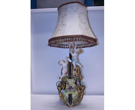 A very ornate ceramic lamp base in the form of a cello with cherubs h100cm, shipping unavailable 