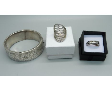 A silver bangle and two silver rings, (bangle dented) 