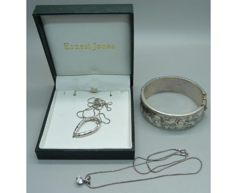 A silver bangle and two silver pendants and chains, 41g 