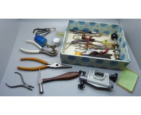 A collection of watchmaker's tools and a vice 