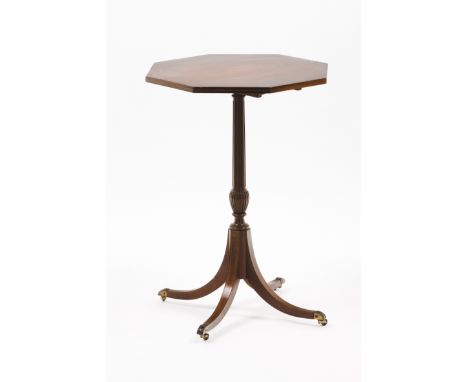 A George III style tripod tableSolid and veneered mahoganyOctagonal topStriated and carved central shaftMetal castorsPortugal