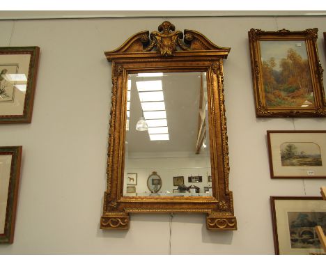 An 18th Century style giltwood wall mirror with broken arch and shield pediment, bevelled glass